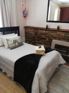 1 dormitorio con 1 cama con espejo y chimenea en KIHARA GUESTHOUSE, en Bethlehem