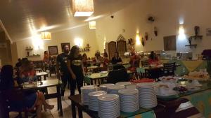 un grupo de personas de pie en una habitación con platos en las mesas en Molise Hotel Fazenda, en Serra Negra 97 fotos más