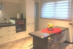a kitchen with a table with a vase of fruit on it at Casetta Helena in Trieste