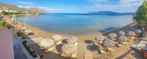 - une vue aérienne sur une plage avec des parasols dans l'établissement Maria Beach Hotel, à Kíssamos