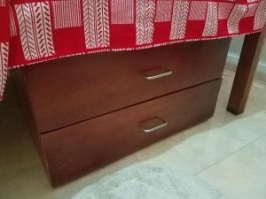 a wooden dresser with a red blanket on top at Sharp Guesthouse in Accra