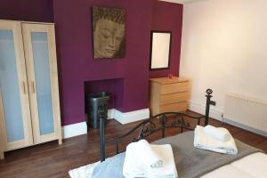 a bedroom with a bed with a head on the wall at South Shield's Hidden Gem Garnet 3 Bedroom Apartment sleeps 6 Guests in South Shields