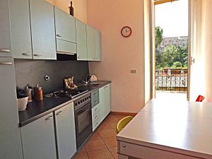 una cucina con armadi bianchi e piano cottura di Casa Ariodante a Perugia