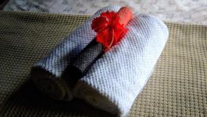 a white towel with a red flower on it at Soul Fire Casitas in Montezuma