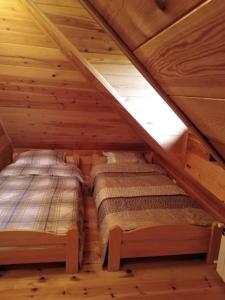 two beds in the attic of a log cabin at Apartmani Milojević in Divčibare