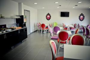 - une salle à manger avec des chaises colorées et une table dans l'établissement Adonis La Baule, à La Baule