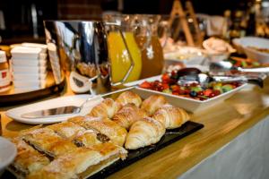 a table topped with croissants and a plate of food at VILLA BRICOLA - Boutique Apartments in Karlovy Vary