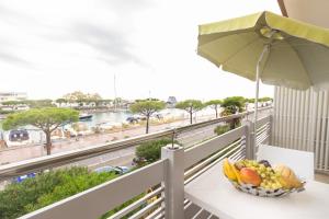 eine Schale Obst auf einem Tisch auf einem Balkon mit einem Sonnenschirm in der Unterkunft Yachting residence in Lignano Sabbiadoro