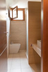 ein Bad mit einem Waschbecken, einem WC und einem Fenster in der Unterkunft Case Fiorite in Riola Sardo