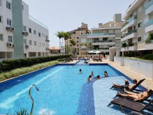 un grupo de personas en una piscina en un complejo en Apartamento Completo na Praia dos Ingleses, en Florianópolis