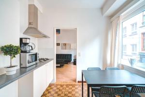 eine Küche und ein Esszimmer mit einem Tisch und Stühlen in der Unterkunft Cute Cozy Apartment in Historic Center in Antwerpen