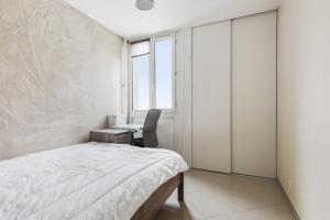 蒙桑巴勒爾的住宿－Luxurious flat in Mons-en-Baroeul close to Lille - Welkeys，一间卧室配有一张床、一张书桌和一个窗户。