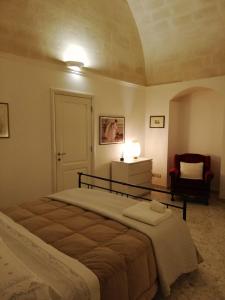 una camera con un grande letto e una sedia di Casa Vacanze Patrizia a Montescaglioso