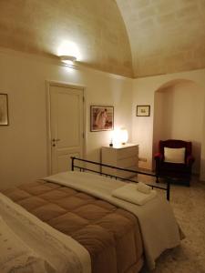 a bedroom with a large bed and a chair at Casa Vacanze Patrizia in Montescaglioso