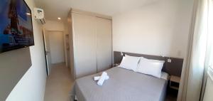 Una pequeña habitación con una cama con un objeto blanco. en Apartamento Gaivotas - 20 metros do mar, lazer e home office, en Florianópolis 27 fotos más