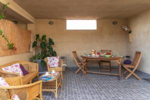 a patio with a table and chairs in a room at Case Fiorite in Riola Sardo