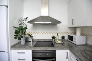 a white kitchen with a sink and a microwave at Apartamento Mediterraneo in Málaga