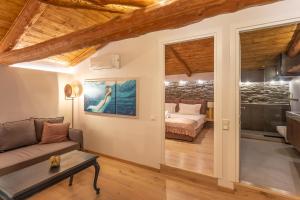 a living room with a couch and a bed at CAMARA SUITES in Andros