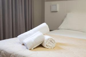 ein Stapel Handtücher auf einem Bett in der Unterkunft Hotel Lunes in São José + 63 Fotos