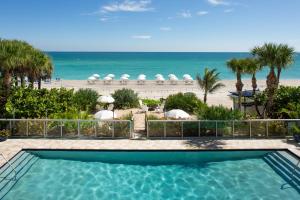 een zwembad met strand op de achtergrond bij Sole Miami, A Noble House Resort in Miami Beach