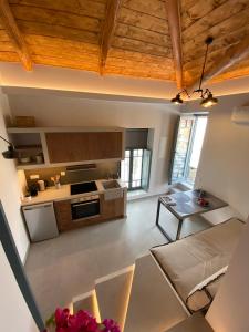 a large kitchen with wooden ceilings and a table at CAMARA SUITES in Andros