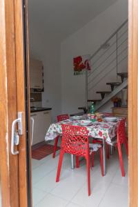 einen roten Tisch und Stühle in einer Küche mit einer Treppe in der Unterkunft Case Fiorite in Riola Sardo