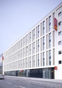 a large white building on a city street at Aparthotel Adagio Köln City in Cologne