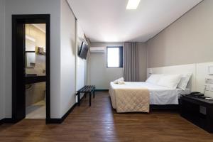 ein Hotelzimmer mit Bett und Badezimmer in der Unterkunft Hotel Lunes in São José