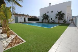 an image of a yard with grass and a swimming pool at Apartamento Lopagan Entremares in Lo Pagán