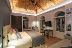 a bedroom with a bed and a desk with a computer at CAMARA SUITES in Andros