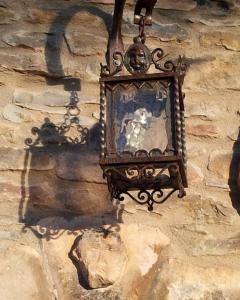 a clock hanging on the side of a stone wall at Casa Rural La Choca in Lecina