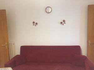 a living room with a couch and a clock on the wall at App sul lungomare in San Benedetto del Tronto