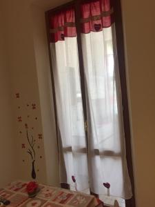 a room with a window and a flower vase on the table at App sul lungomare in San Benedetto del Tronto