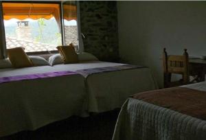 a bedroom with two beds and a window at Casa Rural La Choca in Lecina