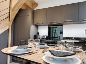 a kitchen with a wooden table with wine glasses at La Viralamande by Cocoonr in Crépieux-la-Pape +8 photos