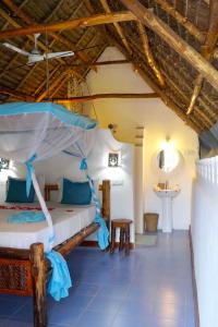 a bedroom with a bed and a sink in a room at Laguna Palace Zanzibar in Michamvi