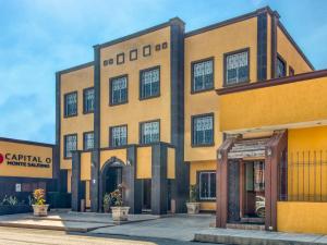 un edificio amarillo y negro con entrada en Monte Salerno Hotel & Suites, en Montemorelos