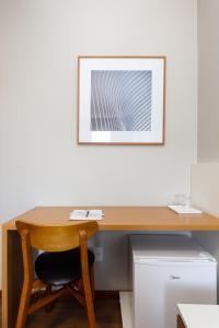 ein Schreibtisch mit Stuhl und ein Bild an der Wand in der Unterkunft Hotel Lunes in São José