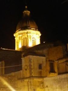 a building with a tower lit up at night at B&B Piazza San Benedetto in Militello in Val di Catania