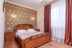 a bedroom with a wooden bed and a window at Home-otel in Krasnodar