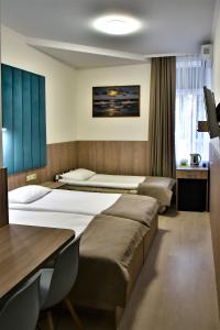 a hotel room with two beds and a desk at EXPO Hotel Comfort in Kyiv