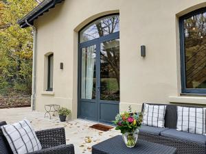 a patio with a blue door with a vase of flowers at La Viralamande by Cocoonr in Crépieux-la-Pape