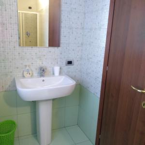 uma casa de banho com um lavatório branco e um espelho. em B&B Cascina Baraggione em Granozzo con Monticello