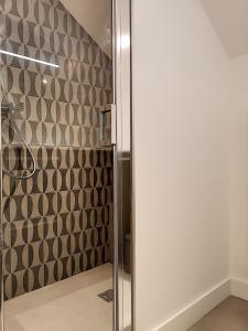 La salle de bains est pourvue d'une douche avec une porte en verre. dans l'établissement La Viralamande by Cocoonr, à Crépieux-la-Pape