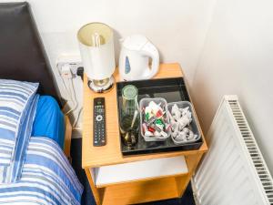 a remote control sitting on top of a bed at La Tavola Calda Hotel in Nuneaton