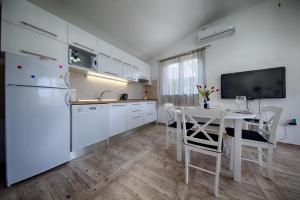 cocina con mesa y nevera blanca en Villa Franceska, en Vis
