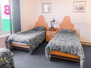 a hospital room with two beds and a dresser at La Tavola Calda Hotel in Nuneaton