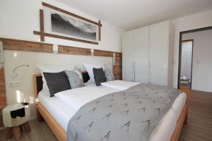 sypialnia z dużym łóżkiem z białą pościelą w obiekcie Dorfliebe w mieście Oy-Mittelberg