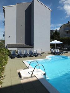 einen Pool mit Stühlen und ein Gebäude in der Unterkunft Residence Lavanda in Umag