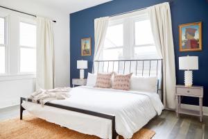een slaapkamer met blauwe muren en een bed met kussens bij Sonder at Viewpoint in New Orleans